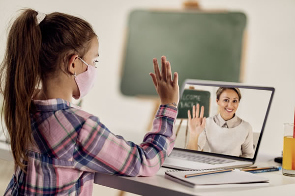 Anak murid sedang belajar secara online menggunakan laptop